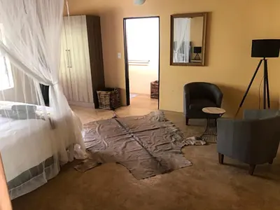 a bedroom with a bed and a rug on the floor at Lion Hill @Kruger in Marloth Park