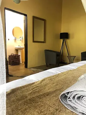 a bedroom with a bed and a desk and a mirror at Lion Hill @Kruger in Marloth Park
