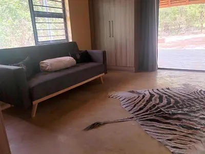 a living room with a couch and a zebra rug at Lion Hill @Kruger in Marloth Park
