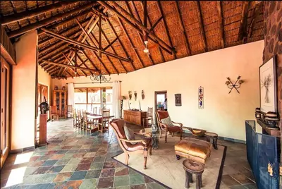 a room with chairs and tables in a building at Metsi Lodge in Welgevonden Game Reserve