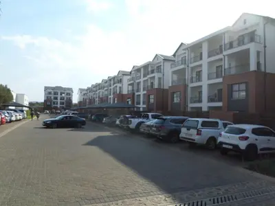 a parking lot with cars parked in front of buildings at The Blyde Crystal Lagoon Cologne4 in Pretoria