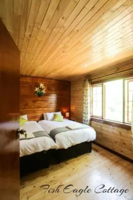 a bedroom with a large bed with a wooden ceiling at Mountain Fly Fishing in Magoebaskloof