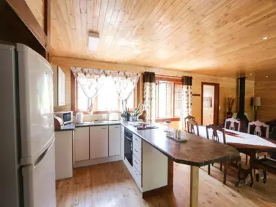 a kitchen with a table and a refrigerator in a room at Mountain Fly Fishing in Magoebaskloof