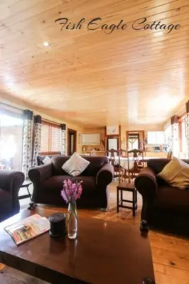 a living room with couches and a table with flowers on it at Mountain Fly Fishing in Magoebaskloof