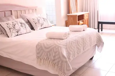 a white bed with two towels on top of it at Die Huis - Self Catering in Bela-Bela