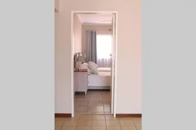 a room with a bedroom with a bed and a mirror at Die Huis - Self Catering in Bela-Bela