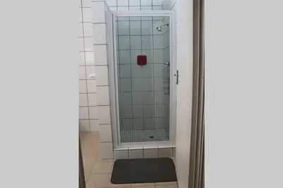 a bathroom with a shower with a glass door at Die Huis - Self Catering in Bela-Bela