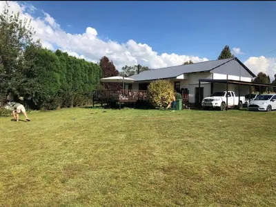 a man standing in a yard in front of a house at Fly Shack in Dullstroom