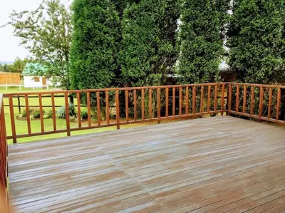 a wooden deck with a wooden fence and trees at Fly Shack in Dullstroom