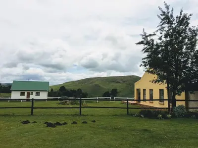 a building with a tree in the middle of a field at Fly Shack in Dullstroom