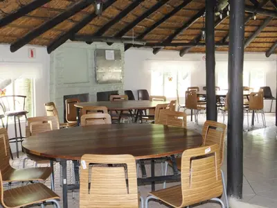 a large wooden table and chairs in a room at Suzie's Loft - NUDE - SunEden Family Naturist Resort in Pretoria