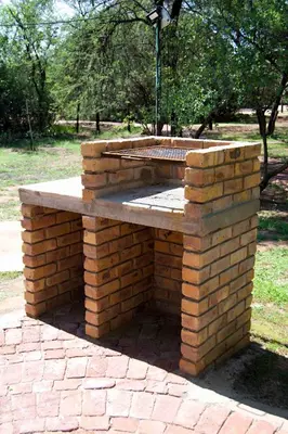a brick fire pit in the middle of a park at Suzie's Loft - NUDE - SunEden Family Naturist Resort in Pretoria