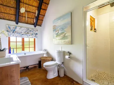 a bathroom with a tub and a toilet and a sink at The Horseshoe Guesthouse in Midrand