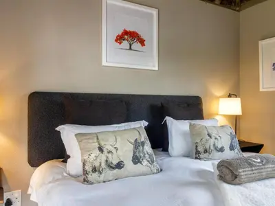 a bed with white sheets and pillows in a bedroom at The Horseshoe Guesthouse in Midrand