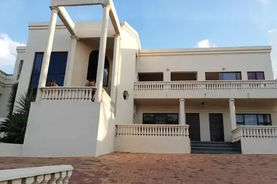 a large white house with a balcony and stairs at Casa de Ross in Pretoria