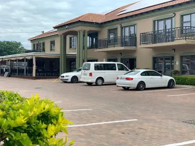 three cars parked in a parking lot in front of a building at Royal Hotel in Polokwane