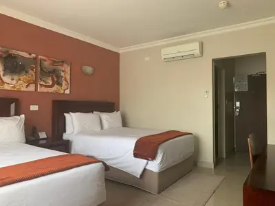 a hotel room with two beds and a bathroom at Royal Hotel in Polokwane
