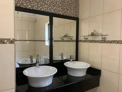 a bathroom with two sinks and a large mirror at Royal Hotel in Polokwane