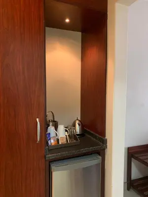 a kitchen with a mirror and a small refrigerator at Royal Hotel in Polokwane