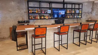 a bar with four chairs and a counter with drinks at Mabalel Lodge in Nelspruit