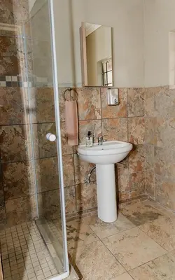 a bathroom with a sink and a shower at Mabalel Lodge in Nelspruit