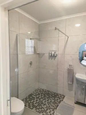a bathroom with a shower with a toilet and a sink at Mabalel Lodge in Nelspruit