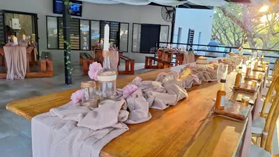a long wooden table with pink napkins on it at Mabalel Lodge in Nelspruit