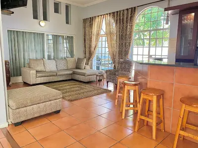 a living room with a couch and a table and chairs at Barberton BnB in Barberton