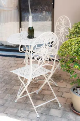 a white wrought iron table and chair on a patio at Barberton BnB in Barberton