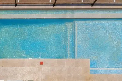 a swimming pool with blue water in a building at Alimama Spaces: The Manson's 8 On New in Midrand