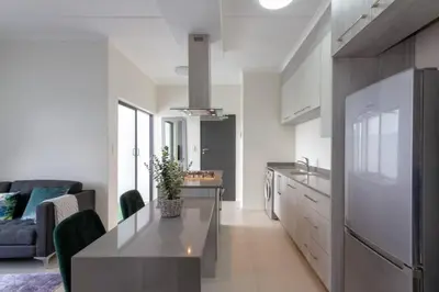 a kitchen and living room with a table and a couch at Alimama Spaces: The Manson's 8 On New in Midrand
