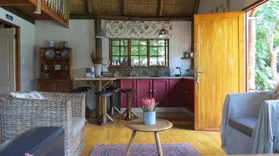 a living room with a kitchen and a table at Ciara Guesthouse in Pretoria