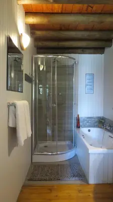 a bathroom with a shower and a bath tub at Ciara Guesthouse in Pretoria