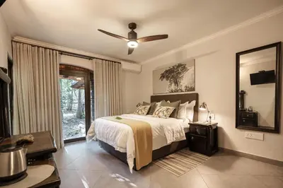 a bedroom with a bed and a ceiling fan at Kruger Eden Lodge in Marloth Park