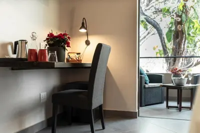 a desk with a chair in a room with a window at Kruger Eden Lodge in Marloth Park