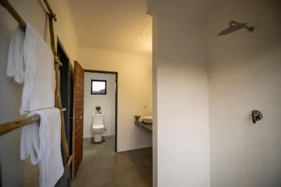 a bathroom with a white toilet and a sink at Kruger Cliffs Lodge - Absolute privacy guaranteed in Hoedspruit