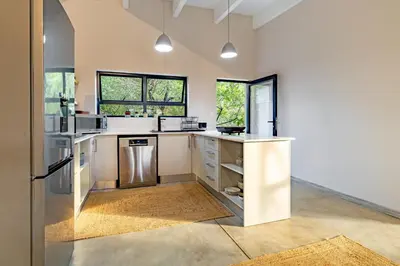a kitchen with white countertops and windows at 444 on Taaibos Bush Villa in Hoedspruit