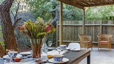 a wooden table with a vase of flowers on it at 444 on Taaibos Bush Villa in Hoedspruit
