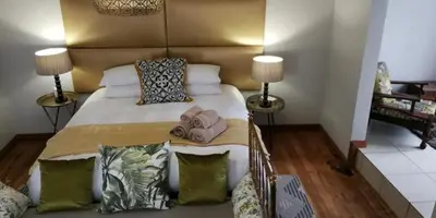 a bedroom with a large bed with two lamps at Green Venus in Kaapsehoop