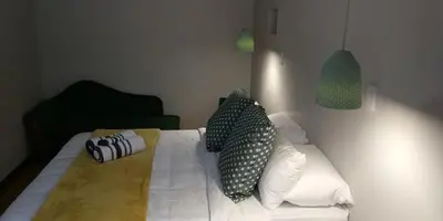 a bedroom with a white bed with pillows on it at Green Venus in Kaapsehoop
