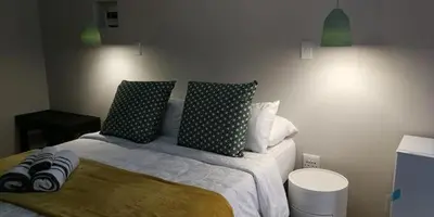 a bedroom with a bed with green and white pillows at Green Venus in Kaapsehoop