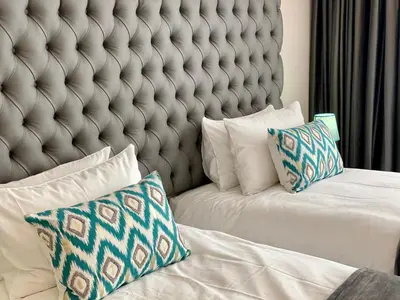 a bedroom with a large headboard and pillows on a bed at Menlyn Maine Residence 11th Floor Apartment in Pretoria