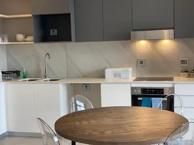 a kitchen with a table and a sink and a stove at Menlyn Maine Residence 11th Floor Apartment in Pretoria