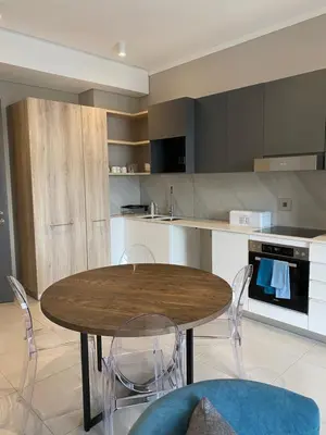 a kitchen with a wooden table and chairs at Menlyn Maine Residence 11th Floor Apartment in Pretoria