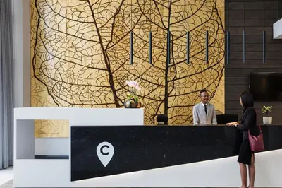 a man and a woman standing at a reception desk at The Capital Trilogy Menlyn Maine in Pretoria