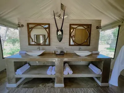 a bathroom with two sinks and two mirrors at Die Boskamp Self-Catering Bush Retreat in Marble Hall
