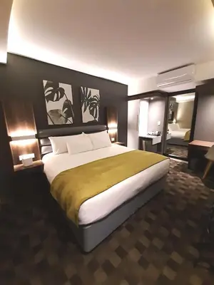 a bedroom with a large bed in a room at Copperwood Hotel and Conferencing in Brits