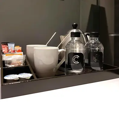 a shelf with two bottles and a cup on it at Copperwood Hotel and Conferencing in Brits