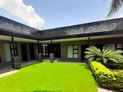 a house with a lawn in front of it at Copperwood Hotel and Conferencing in Brits