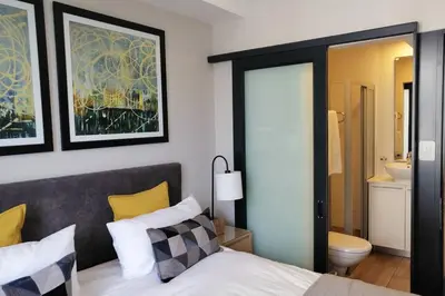 a bedroom with a bed and a bathroom at Regency Apartment Hotel Menlyn in Pretoria